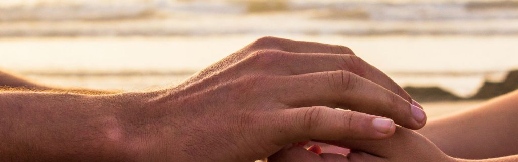 Photo de mains d'homme prenant les mains d'une femme au bord de la mer